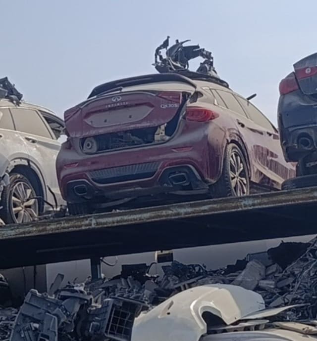 Dark red Infiniti QX30 car for parts, rear view with tailgate, taillights and rear bumper, Sharjah market