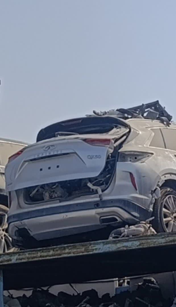 White Infiniti QX50 SUV for parts, rear view — damaged tailgate, rear bumper, alloy wheel, Sharjah market
