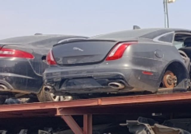Dark grey Jaguar XJ sedan rear view — trunk lid, taillights, bumper and exhaust, Sharjah market