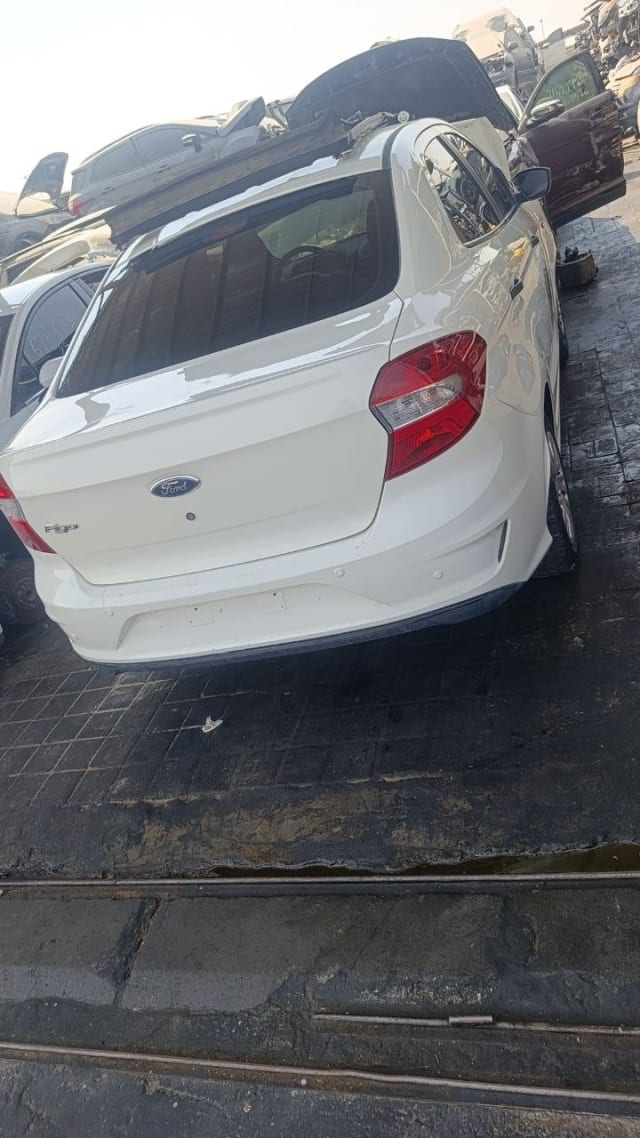 White Ford Figo sedan for parts, rear view — trunk lid, tail lights and rear bumper, Sharjah market