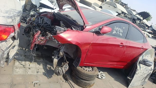 Red Hyundai Elantra halfcut, front stripped with engine, hood, fender and doors visible, Sharjah market