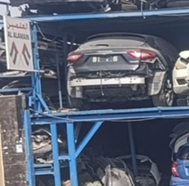 Dark grey Maserati Levante for parts, rear view with tailgate and taillights on a rack, Sharjah market