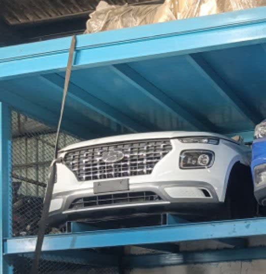 White Hyundai Venue front cut on blue rack: bumper, chrome grille and headlight, Sharjah market