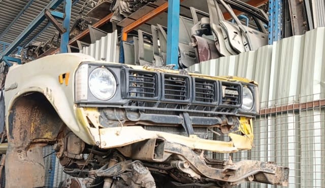 Cream older Toyota Hilux front halfcut with round headlights, black grille, fender and chassis, Sharjah market