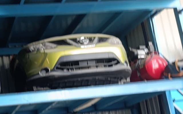Lime green Nissan Qashqai front end with bumper, grille and headlights on a rack, Sharjah market