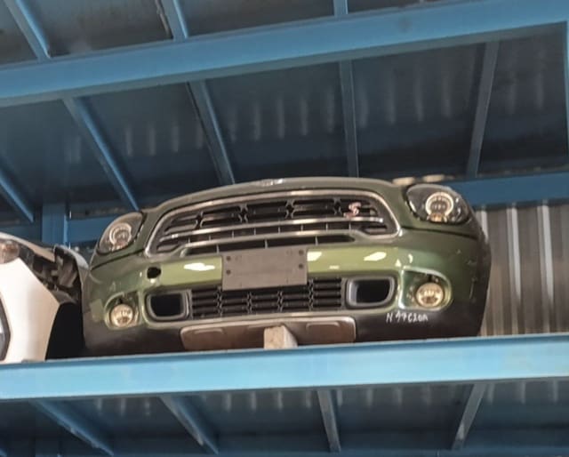 Dark green MINI Countryman front cut with bumper, grille and round headlights on a rack, Sharjah market