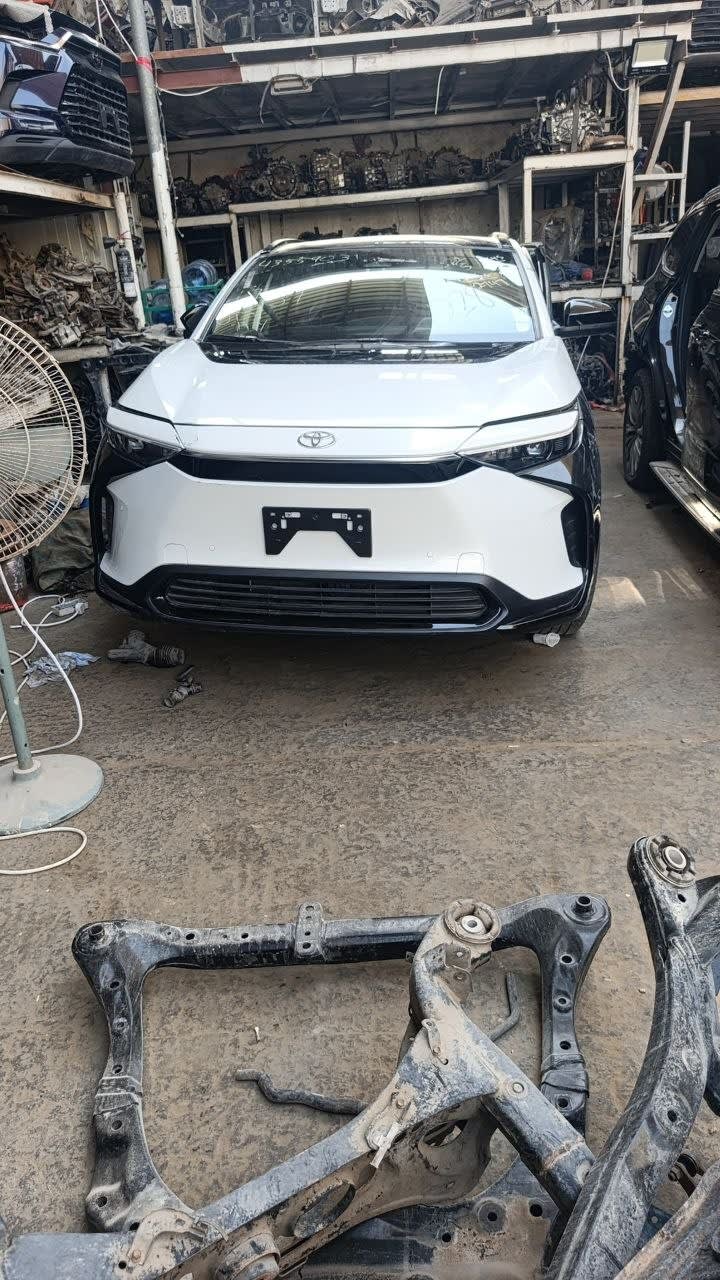White Toyota bZ4X SUV front — bumper, grille and headlights with subframe in foreground, Sharjah market