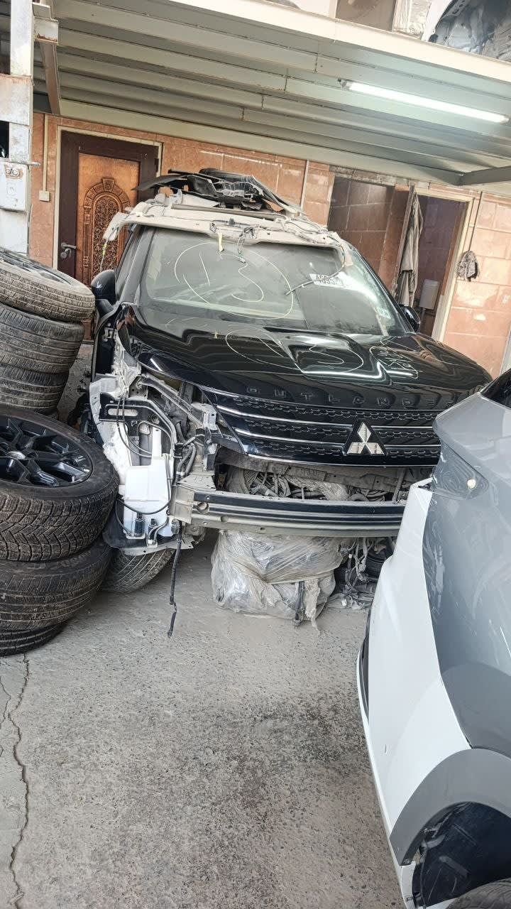 Black Mitsubishi Outlander SUV halfcut — hood, grille and windshield, front bumper removed, Sharjah market