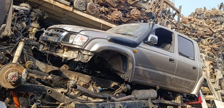 Silver-grey Toyota Hilux double cab pickup halfcut — fender, headlight, doors and engine bay, Sharjah market