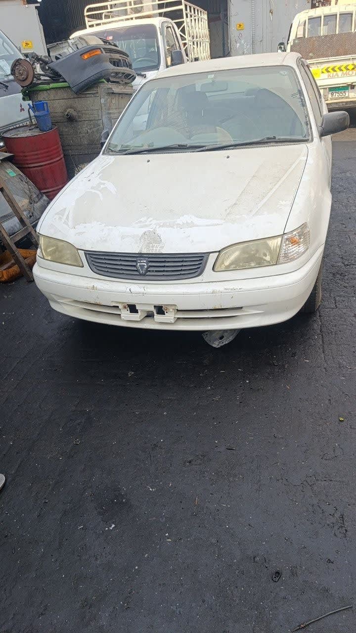 White Toyota Corolla sedan front — hood, grille, headlights and bumper, Sharjah market