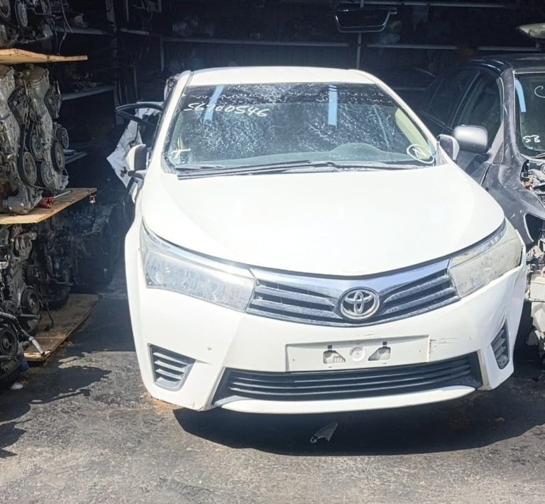 White Toyota Corolla sedan front cut — bumper, grille and headlights, Sharjah market