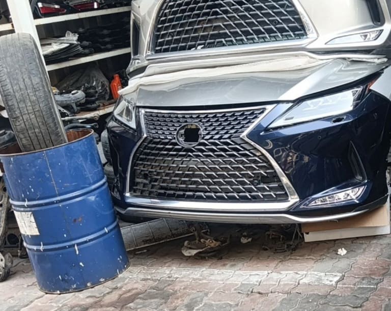 Dark blue Lexus RX SUV front halfcut — spindle grille, bumper and headlights, Sharjah market