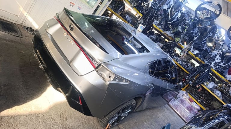 Silver Lexus LC500 coupe halfcut rear — quarter panel, tail lights, trunk and alloy wheel, Sharjah market