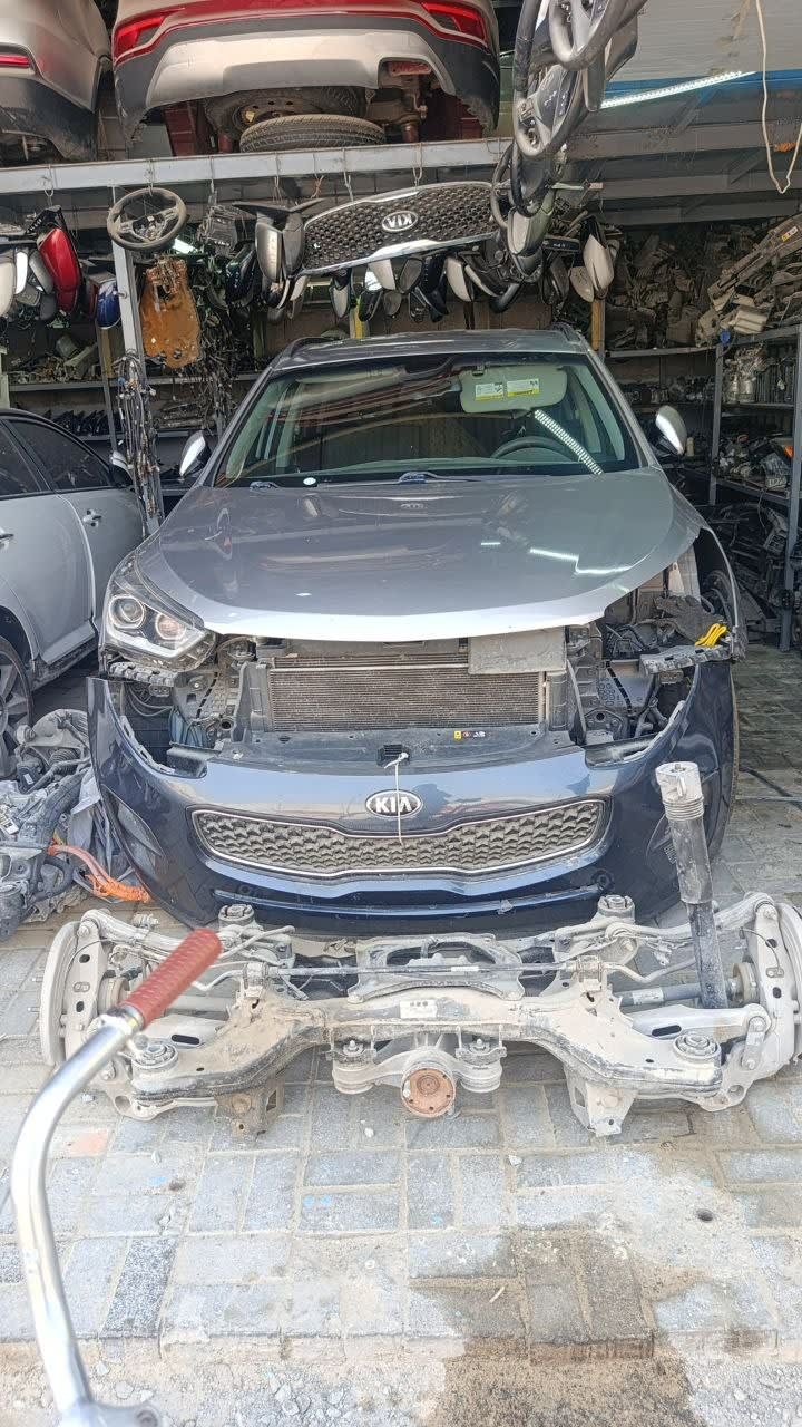 Dark grey Kia Sportage SUV front halfcut — bumper, grille, headlights and radiator, Sharjah market