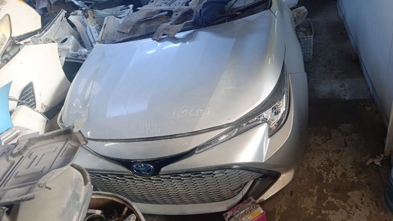 Silver Toyota Corolla hatchback front cut — hood, grille and right headlight, Sharjah market