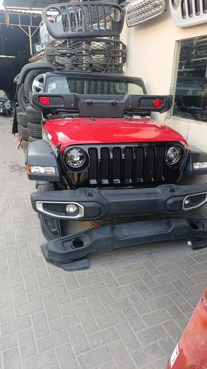 Red Jeep Wrangler front cut — seven-slot grille, LED headlights, hood and front bumper, Sharjah market