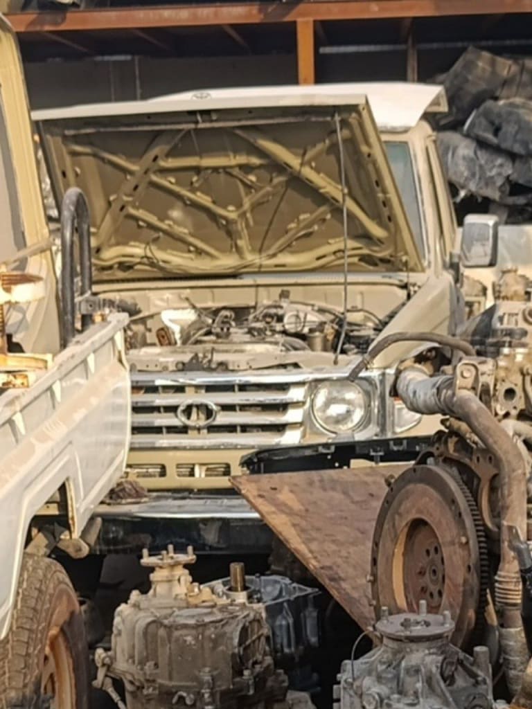 White Toyota Land Cruiser 70 Series pickup halfcut — grille, headlight, hood and engine bay, Sharjah market