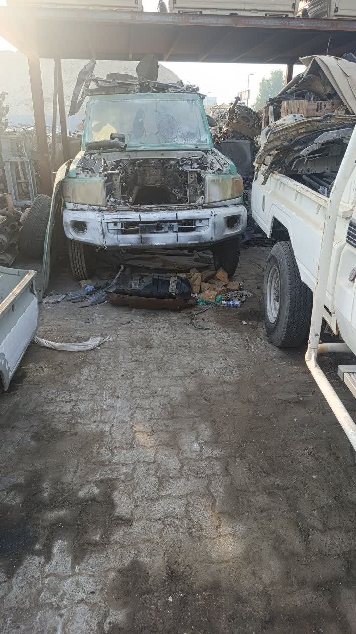 White and green Nissan Patrol SUV halfcut — front bumper, grille and stripped engine bay, Sharjah market