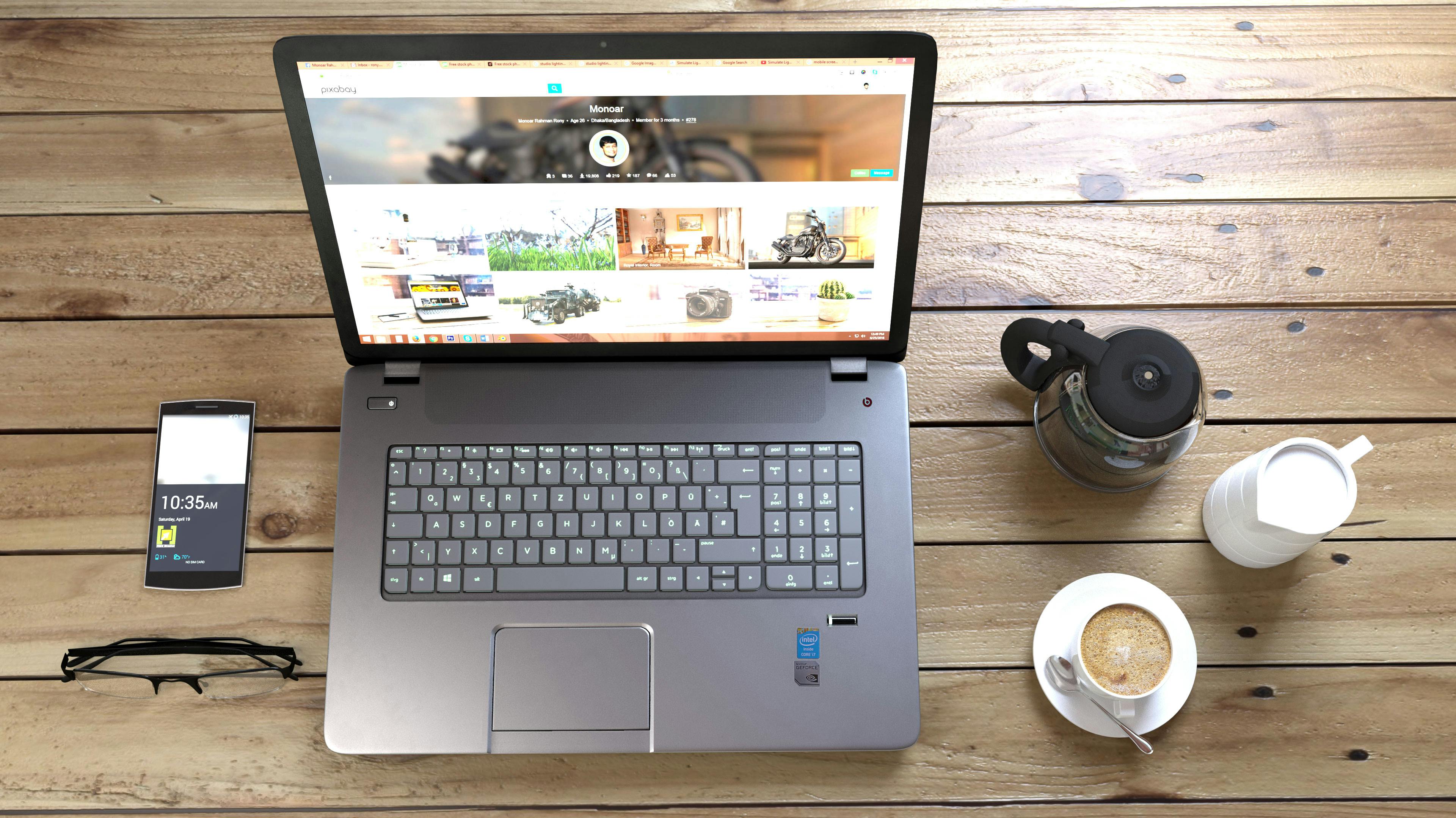 silver laptop next to coffee cup smartphone and glasses