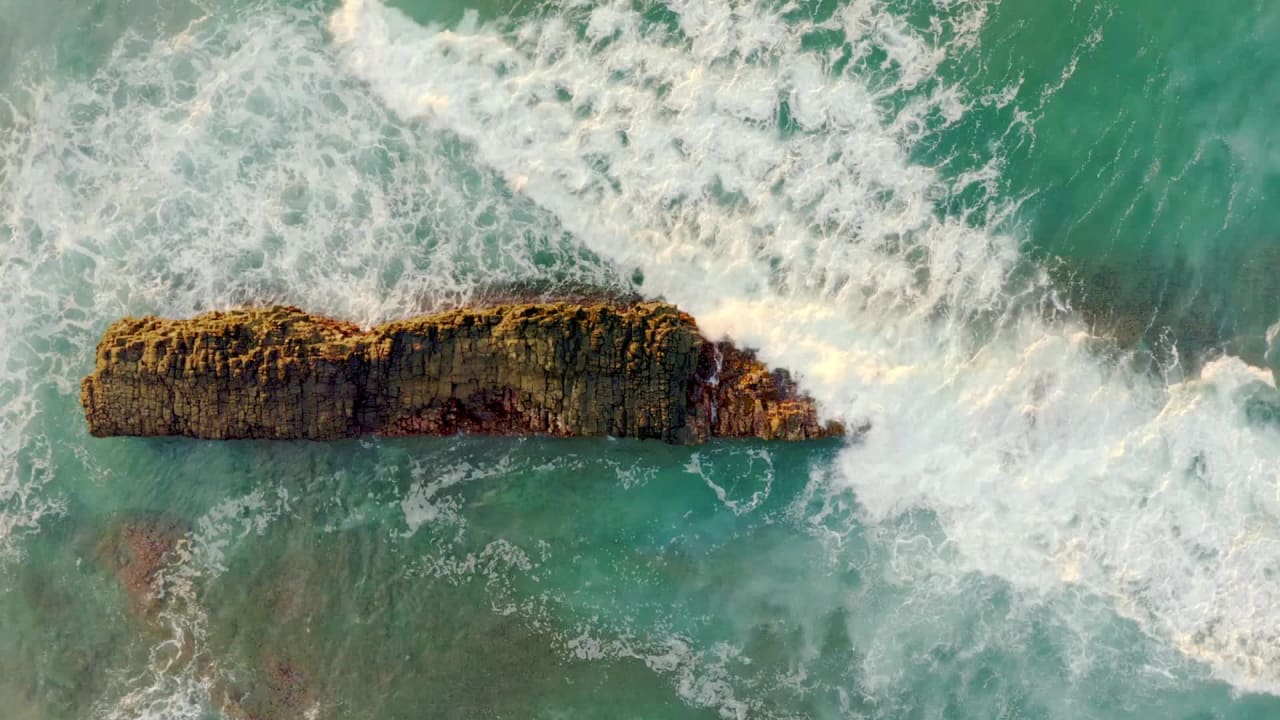 Aerial View of Waves Hitting a Small Cliff preview