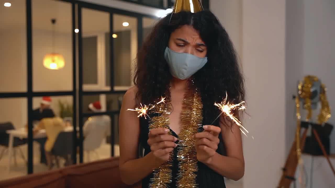 Camera focus on mask girl playing with sparklers preview
