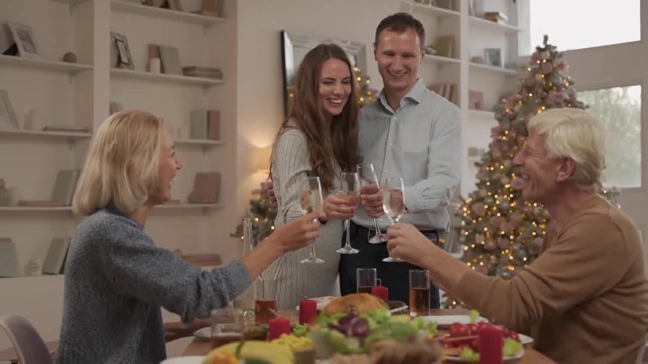 Stock footage of a woman and a man dressed in elegant clothes toast with a glass of champagne and kiss each other preview