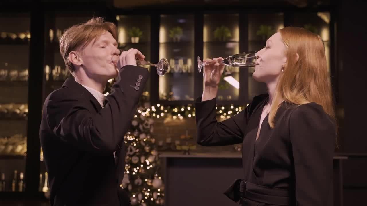 Stock footage of a woman and a man dressed in elegant clothes toast with a glass of champagne preview