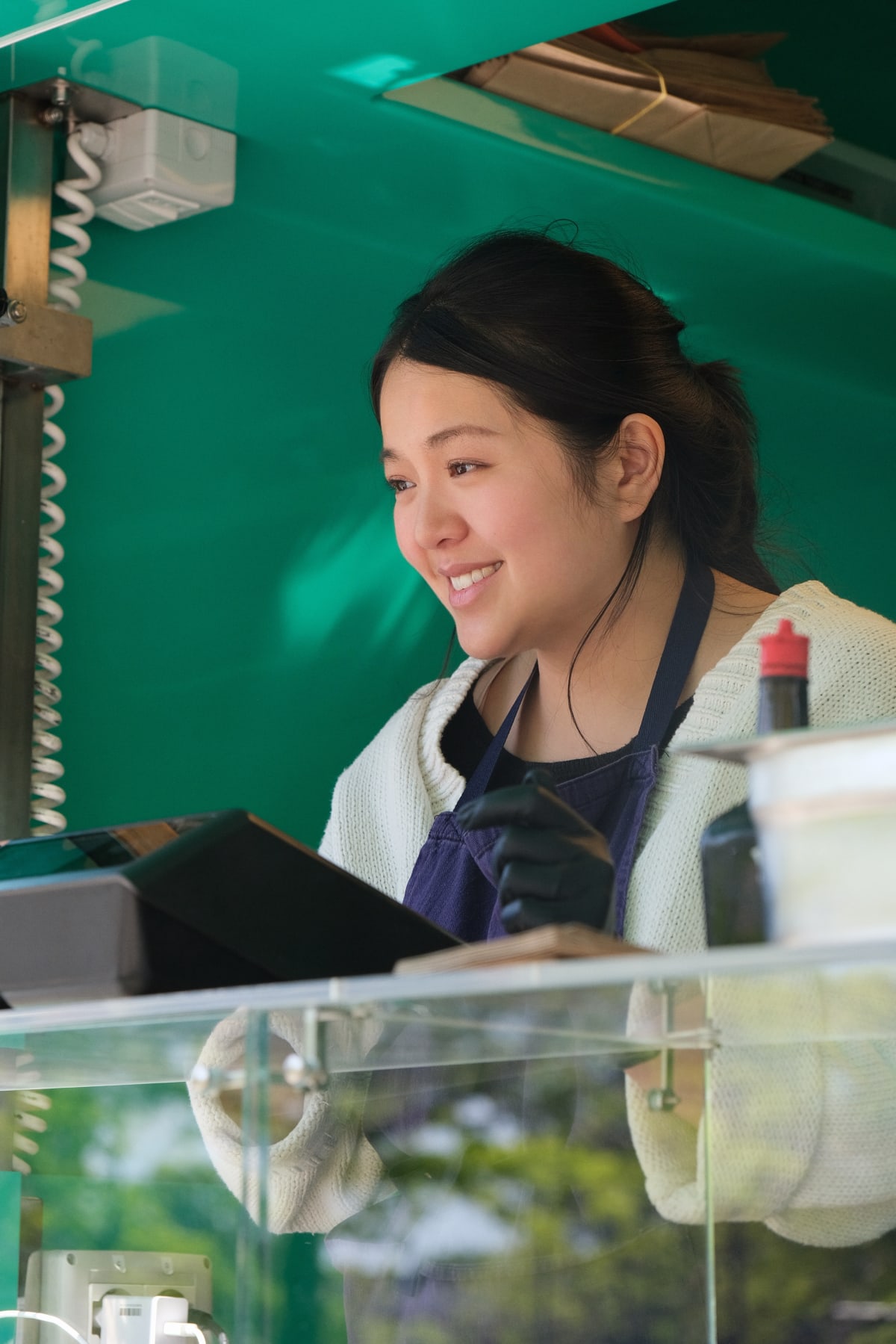 Une food-trucker de Banh Banh au comptoir de son food truck à Rennes, tablette de commande à l'écran