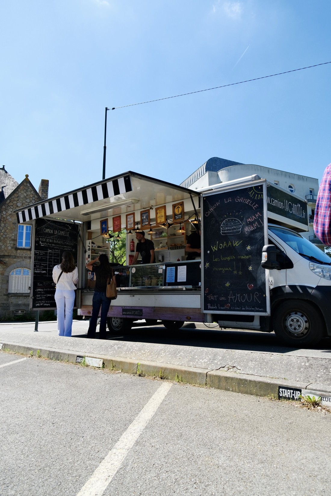 Le camion La Gamelle en service à Rennes, ardoises menu visibles, deux clients devant le comptoir, ciel bleu d'été