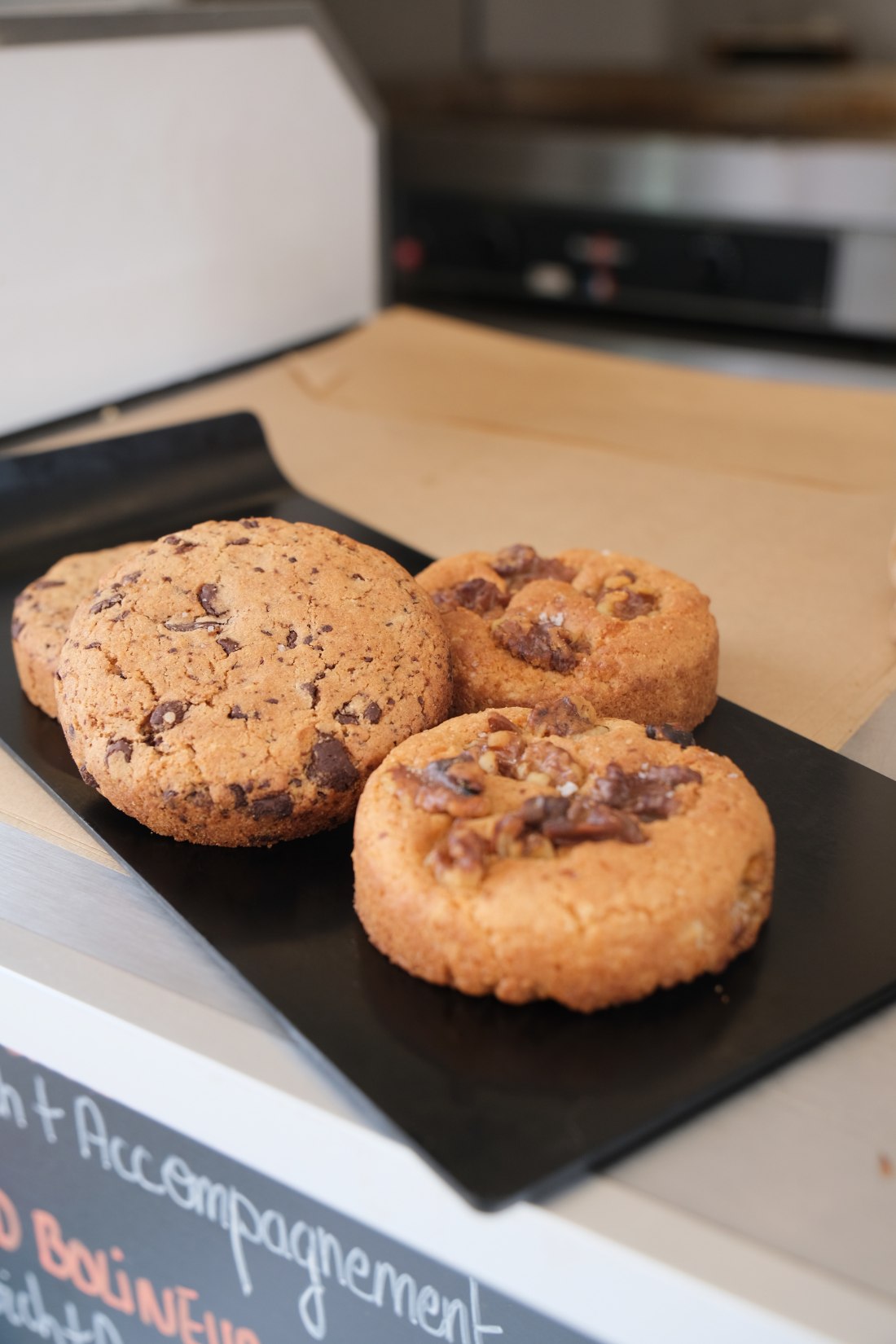 Cookies maison de La Bolinette posés sur une ardoise : pépites de chocolat fleur de sel et noix