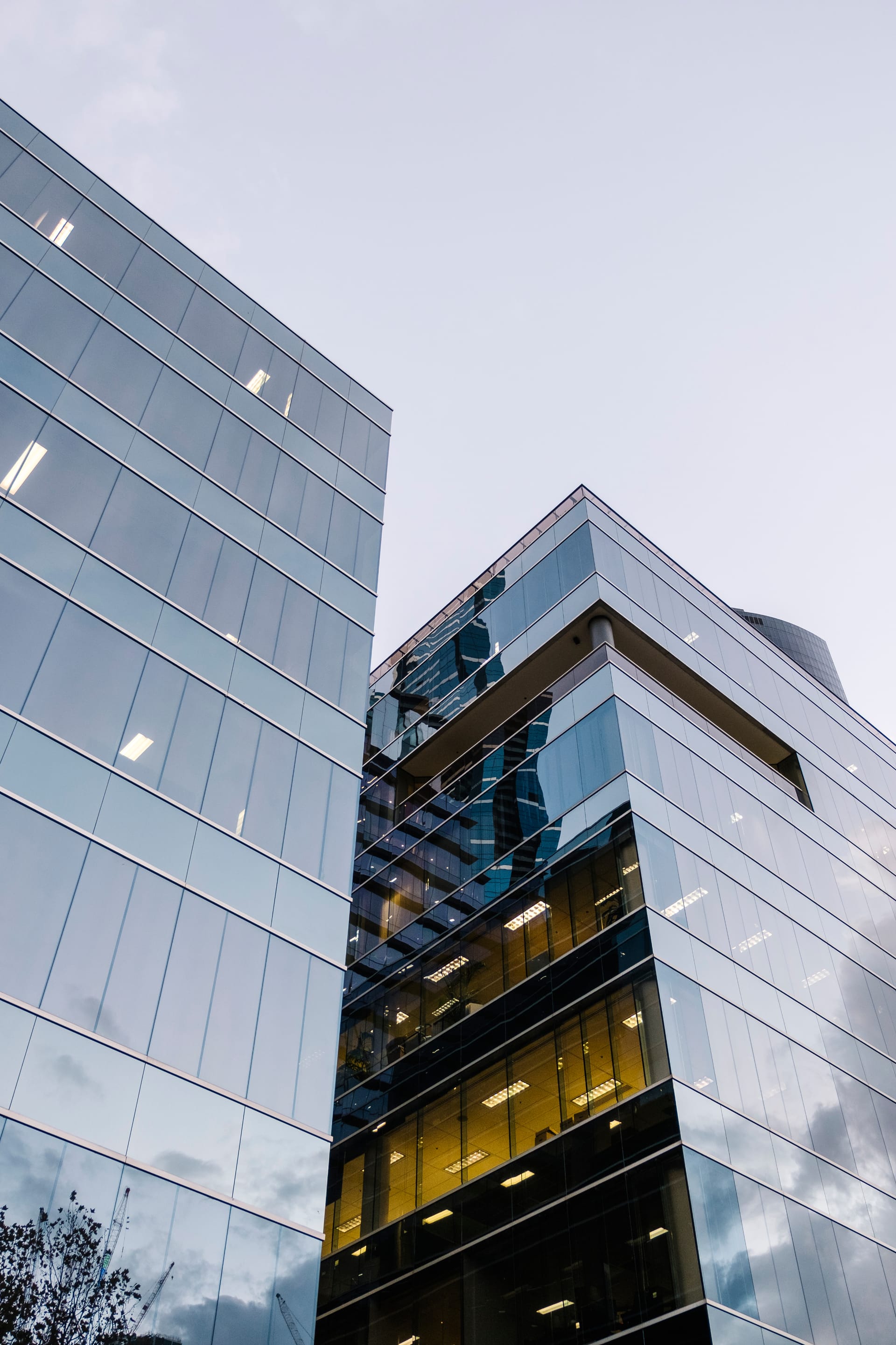 Modern glass office tower facade reflecting the sky