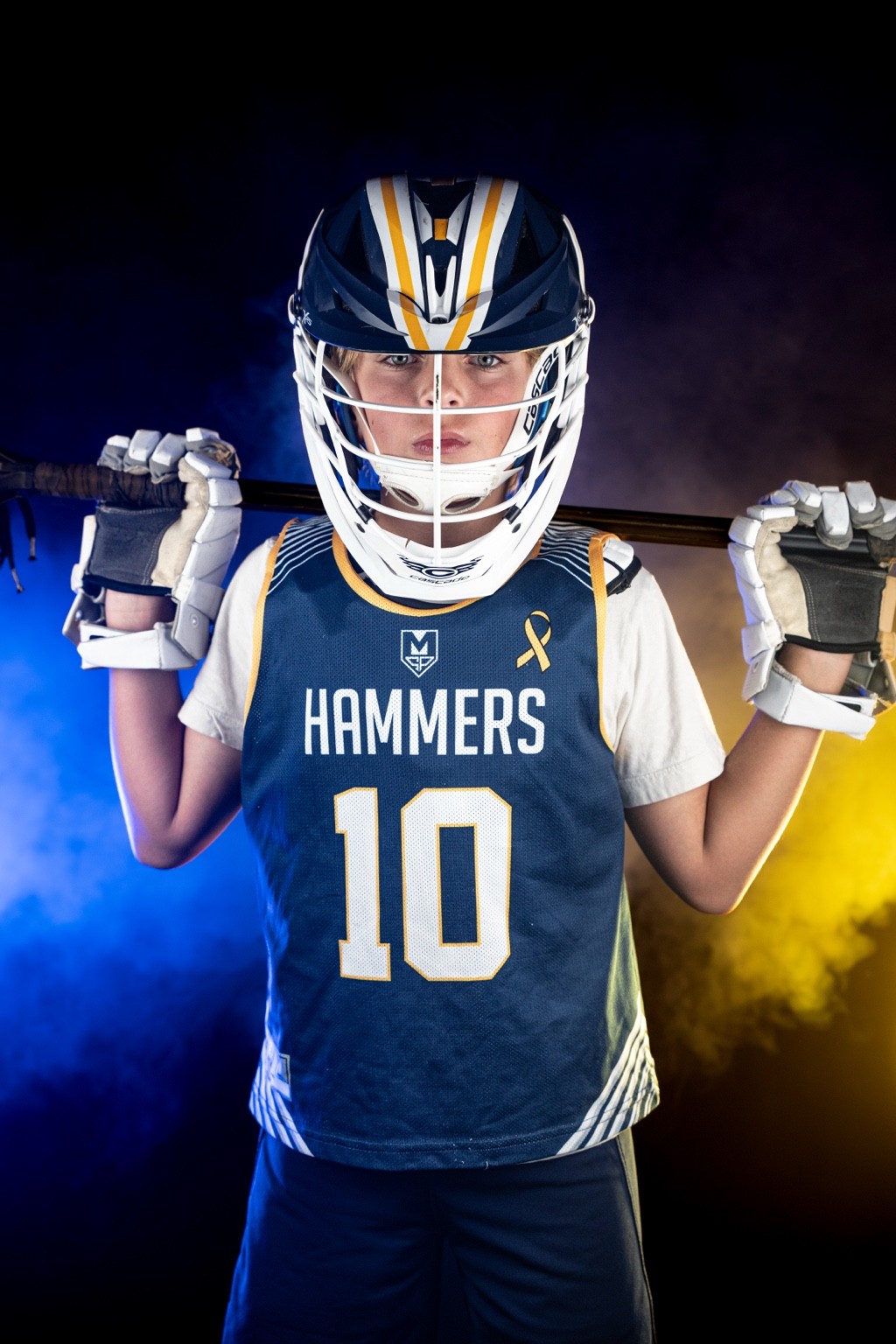 Ashburn Hammers lacrosse player portrait with smoke and blue and yellow team themed lights — creative sports studio photography