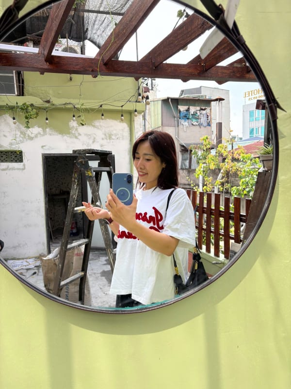 Linh taking a picture of herself with the almost ready homestay