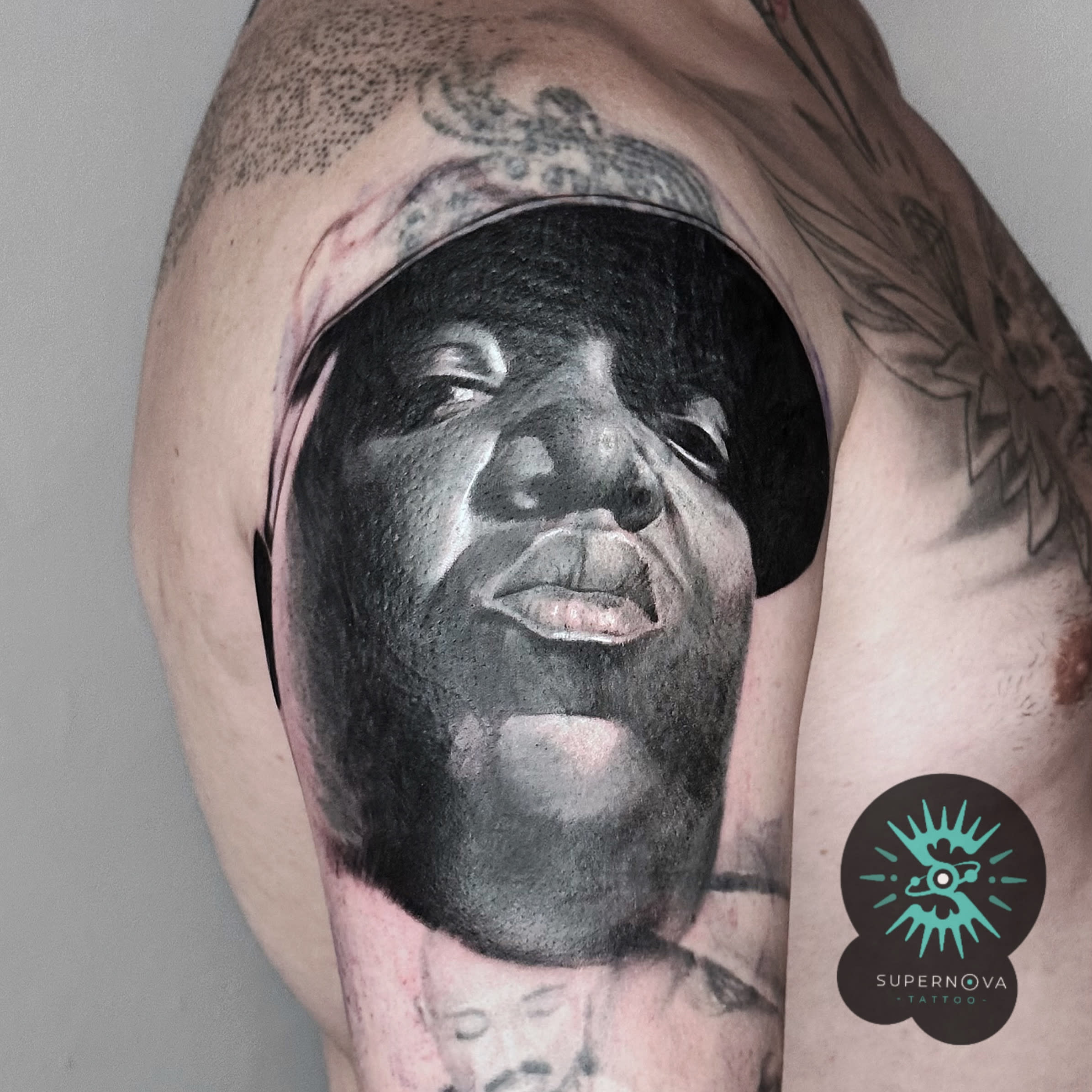 Biggie portrait realism on upper arm