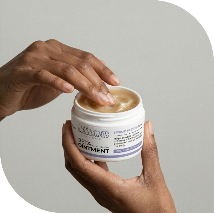 Hand applying Dr. Thrower's Beta Ointment from a jar