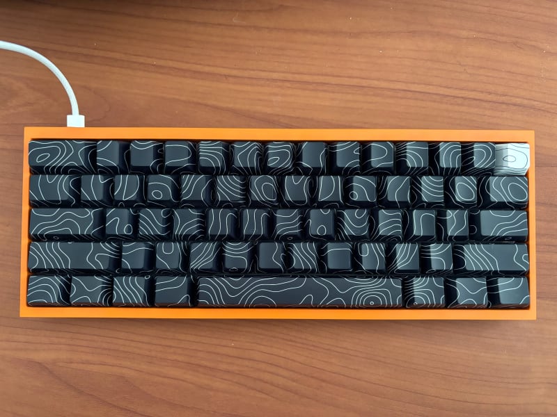 A mirrored keyboard with an orange case as "elevation map" key caps