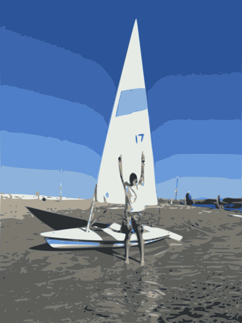 Photo of me standing in front of a beached Laser sailboat