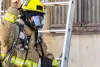 Firefighter standing in front of a ladder