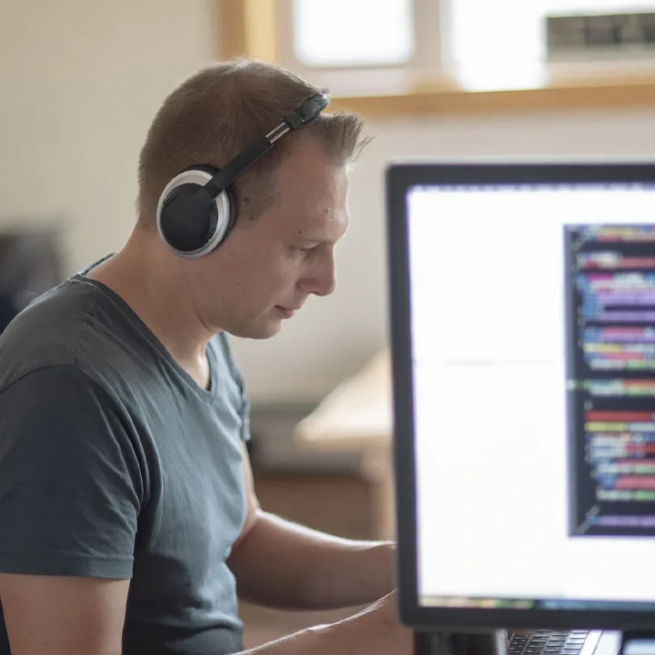 Caballero con auriculares trabajando en una computadora
