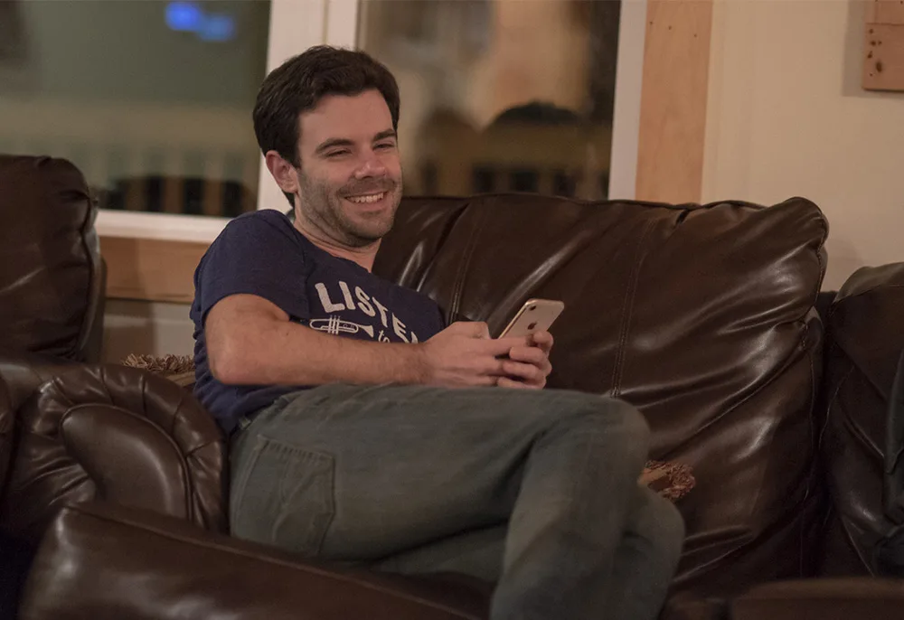 Mann, der auf einem braunen Sofa sitzt