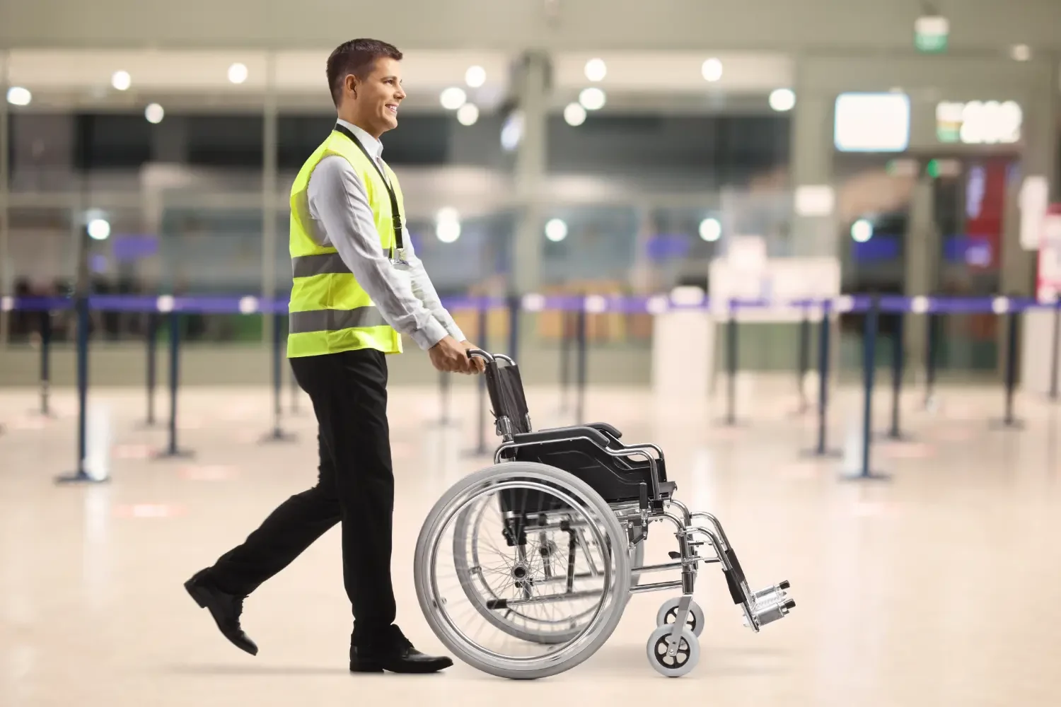 Photo of an airline employee pushing a wheelchair through the terminal