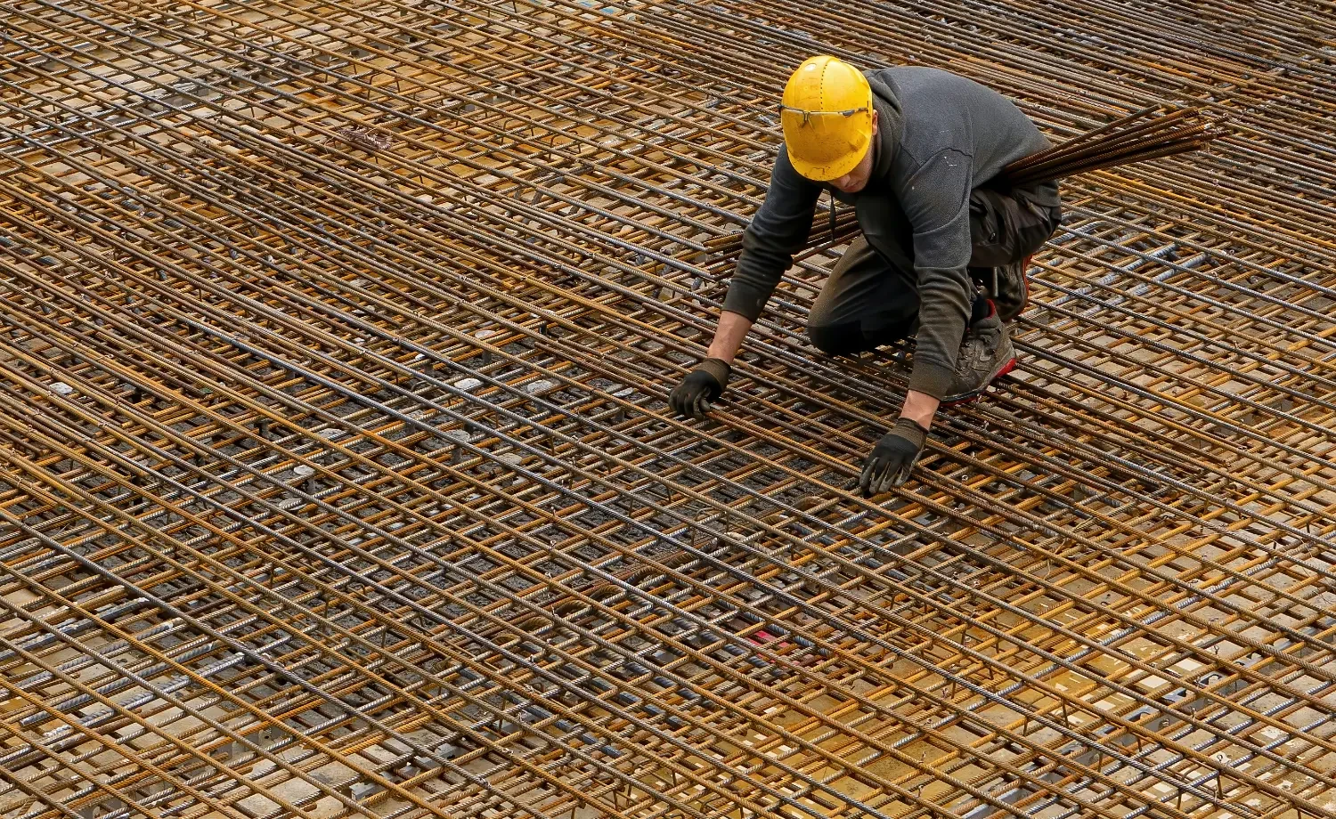 Photo of a construction worker laying out rebar