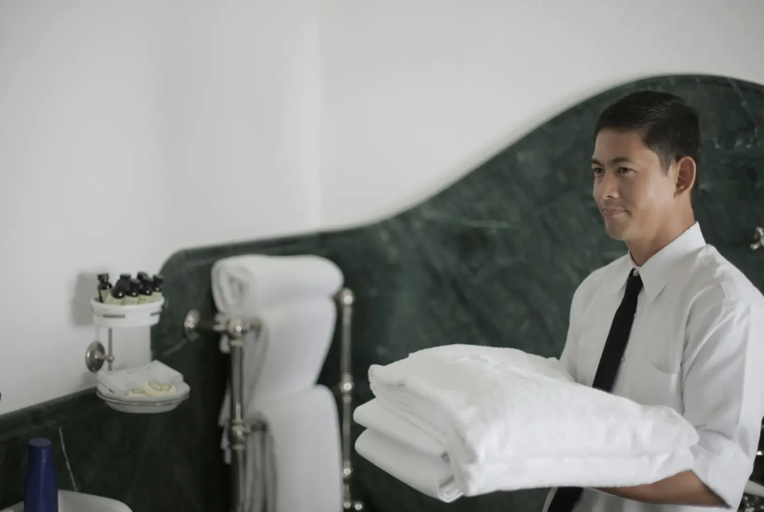 Photo of a hospitality worker holding fresh linens