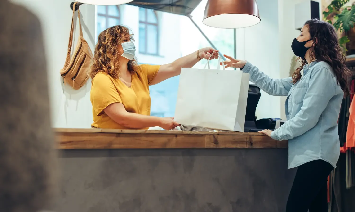 Photo of a retail store worker handing a bag to a customer