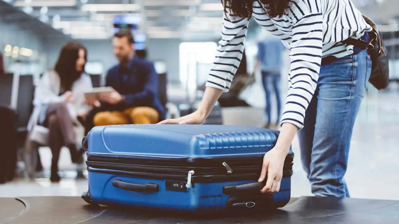 Travelers collecting luggage at Miami International Airport baggage claim area