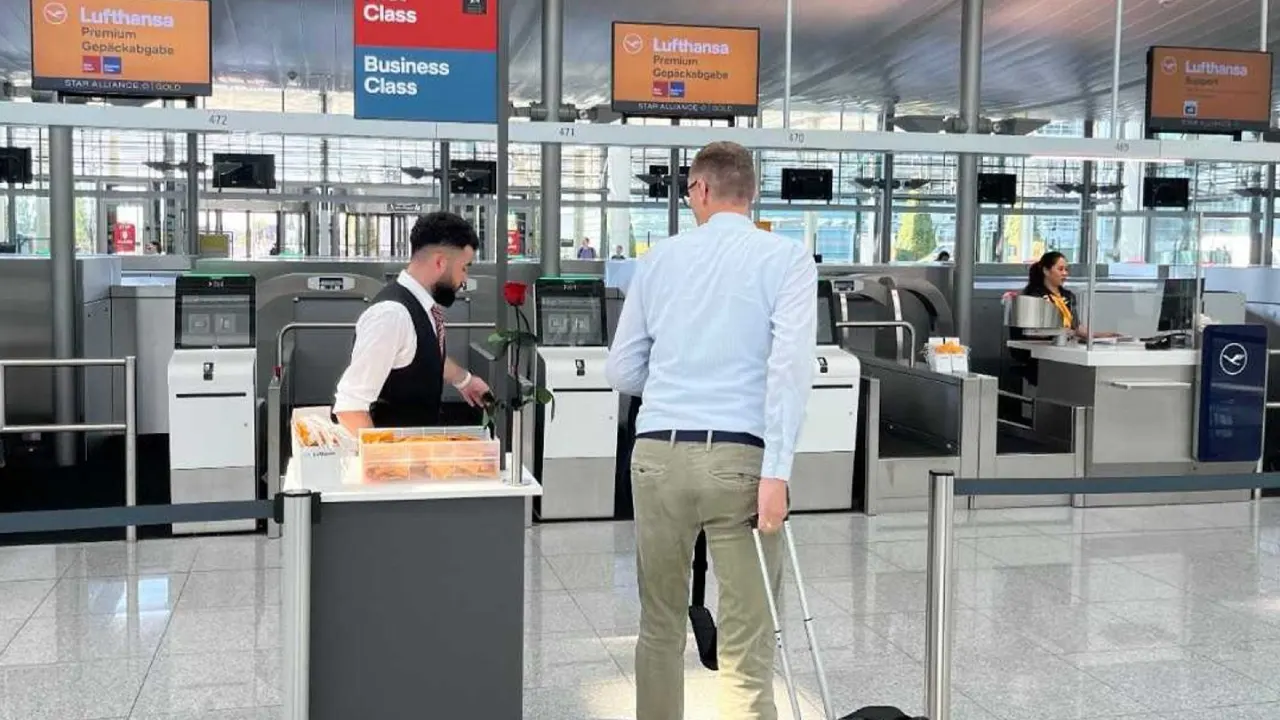 Passengers checking in at Lufthansa airport counter with staff assistance