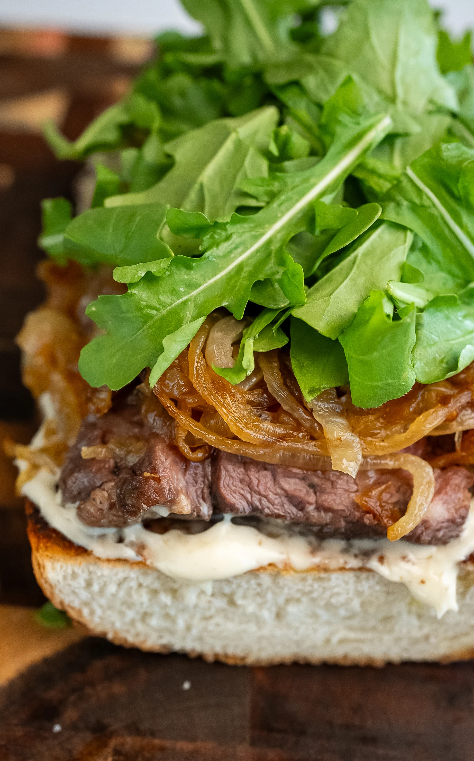 steak-sandwich-with-caramelized-onions-arugula-and-truffle-aioli