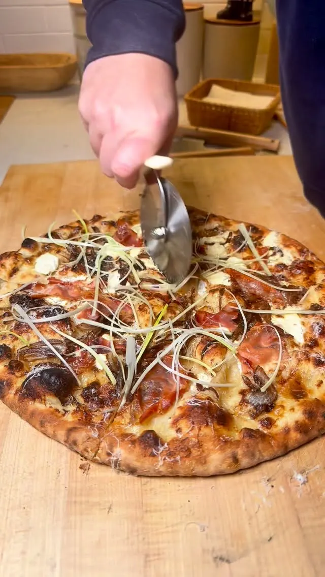 whipped-cream-base-pizza-with-caramelized-onions-prosciutto-goat-cheese-parmigiano-reggiano-and-leeks