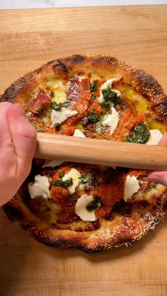 pizza-with-fresh-mozzarella-pesto-vodka-sauce-and-bacon-on-a-sesame-seeded-mozzarella-cheese-base