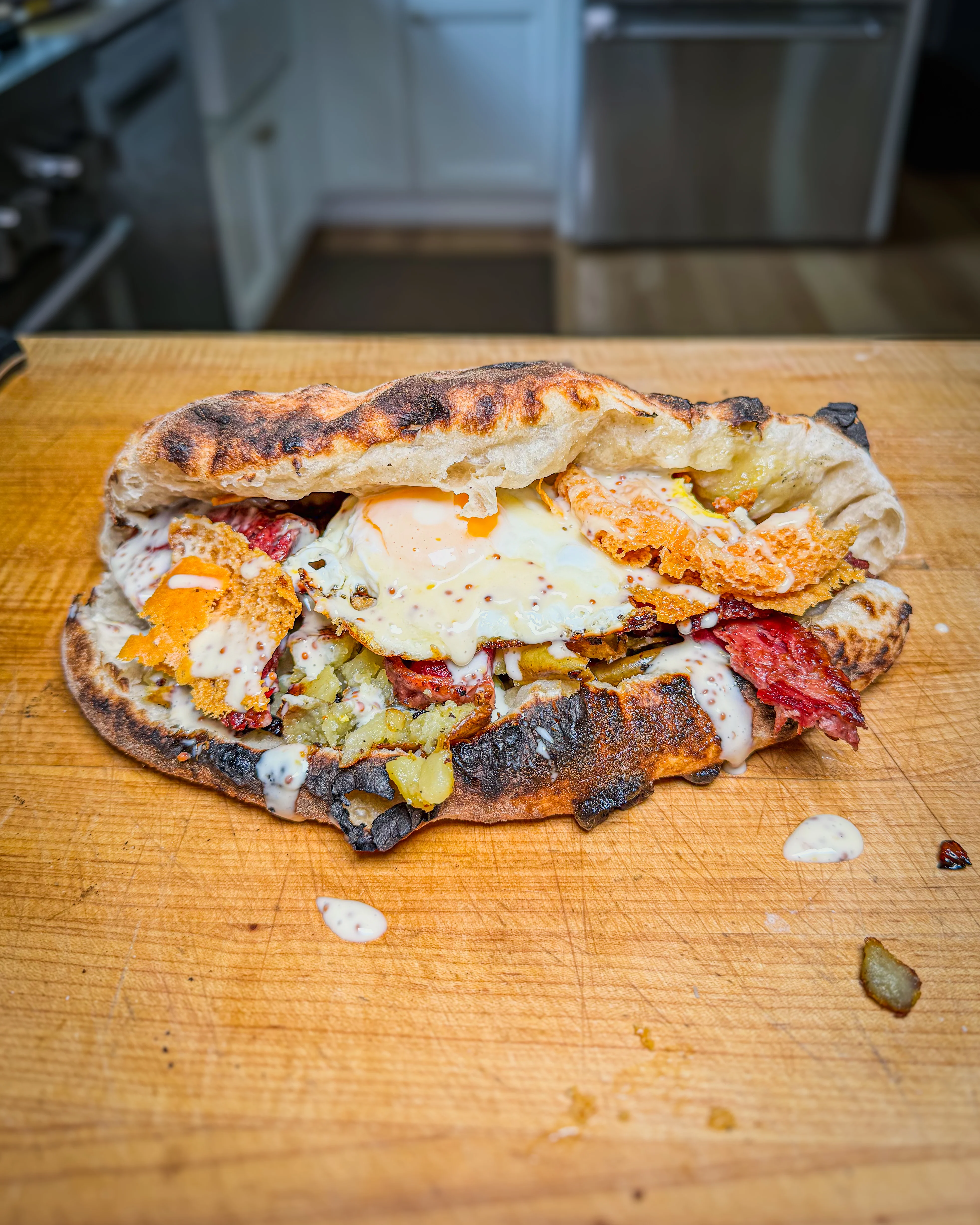 crispy-corned-beef-breakfast-pizza-dough-sandwich-with-smashed-potatoes-red-onions-crispy-cheddar-egg-and-maple-mustard-mayo
